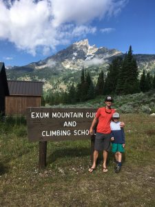 Nat and his son in front of the Exum Mountain Guides sign